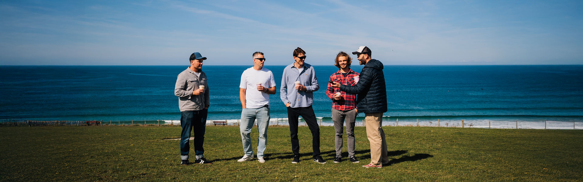 A photo of the team together in front of the sea